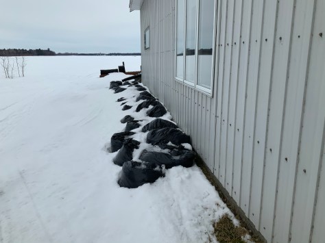 Photo Sacs de poubelles le long du garage municipal, durant l'hiver