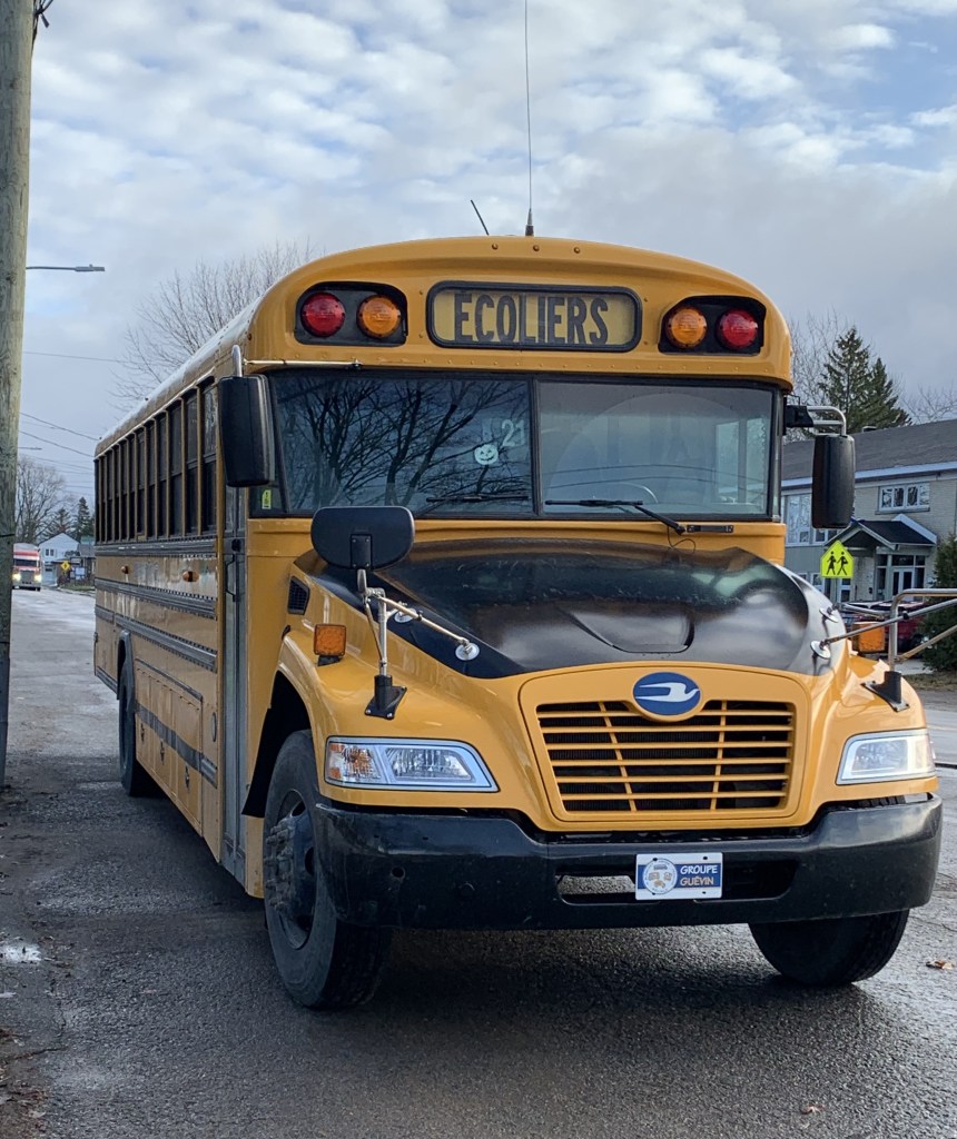 Photo d'une autobus scolaire, numéro 21.
Photo prise dans le village de sainte-monique sur la rue principale le 28 novembre 2022.